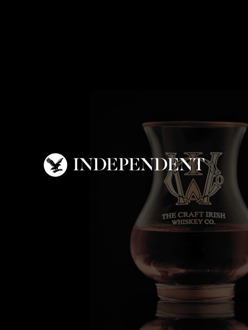 A glass of artisan whiskey and the independent logo