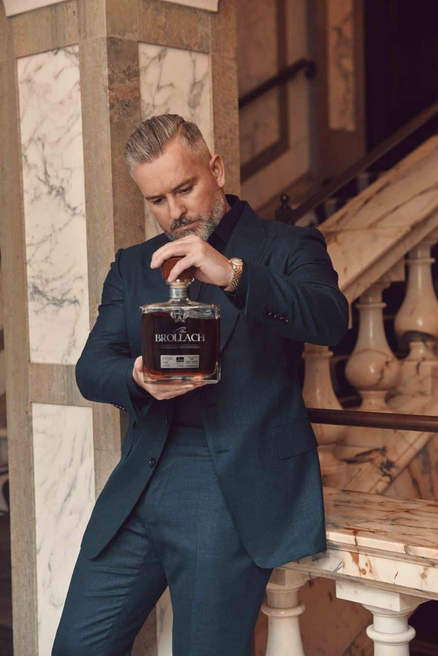 Jay Bradley holding a bottle of The Brollach, a double distilled luxury single malt whiskey