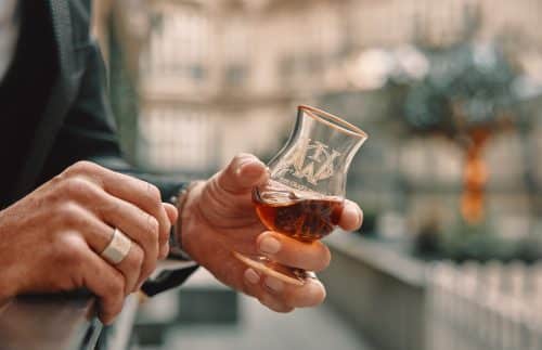 A man holding a luxury whiskey glass