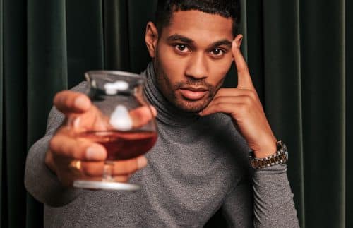 A man holding a glass of award winning whiskey