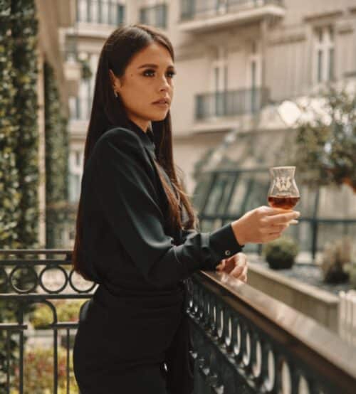 A woman holding a glass of rare Irish whiskey