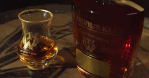 A whiskey glass and a bottle rare Irish whiskey
