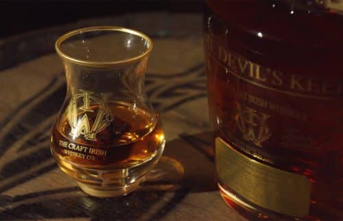 A glass and a bottle of rare, expensive whiskey