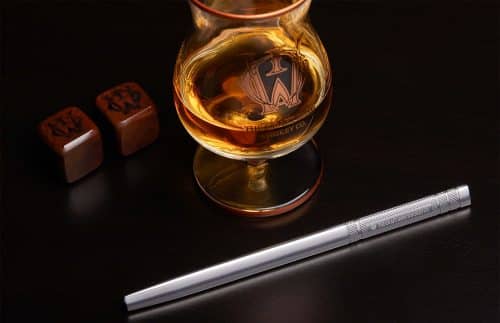 A glass of craft whiskey, 2 obsidian stones and a pipette