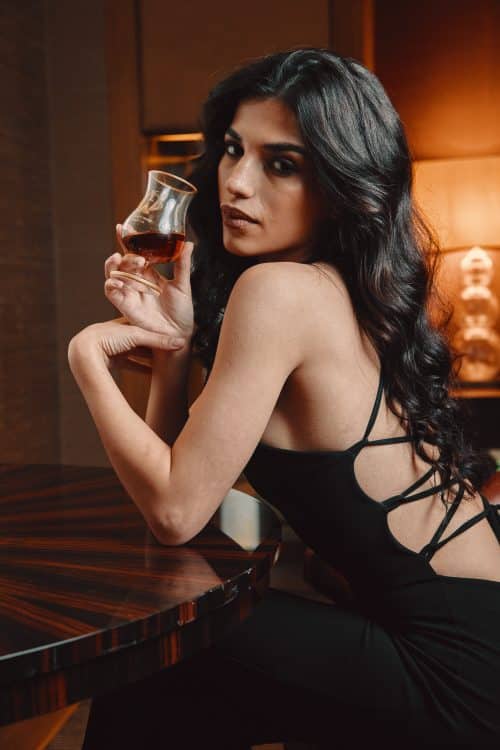 A woman holding a glass of expensive Irish whiskey