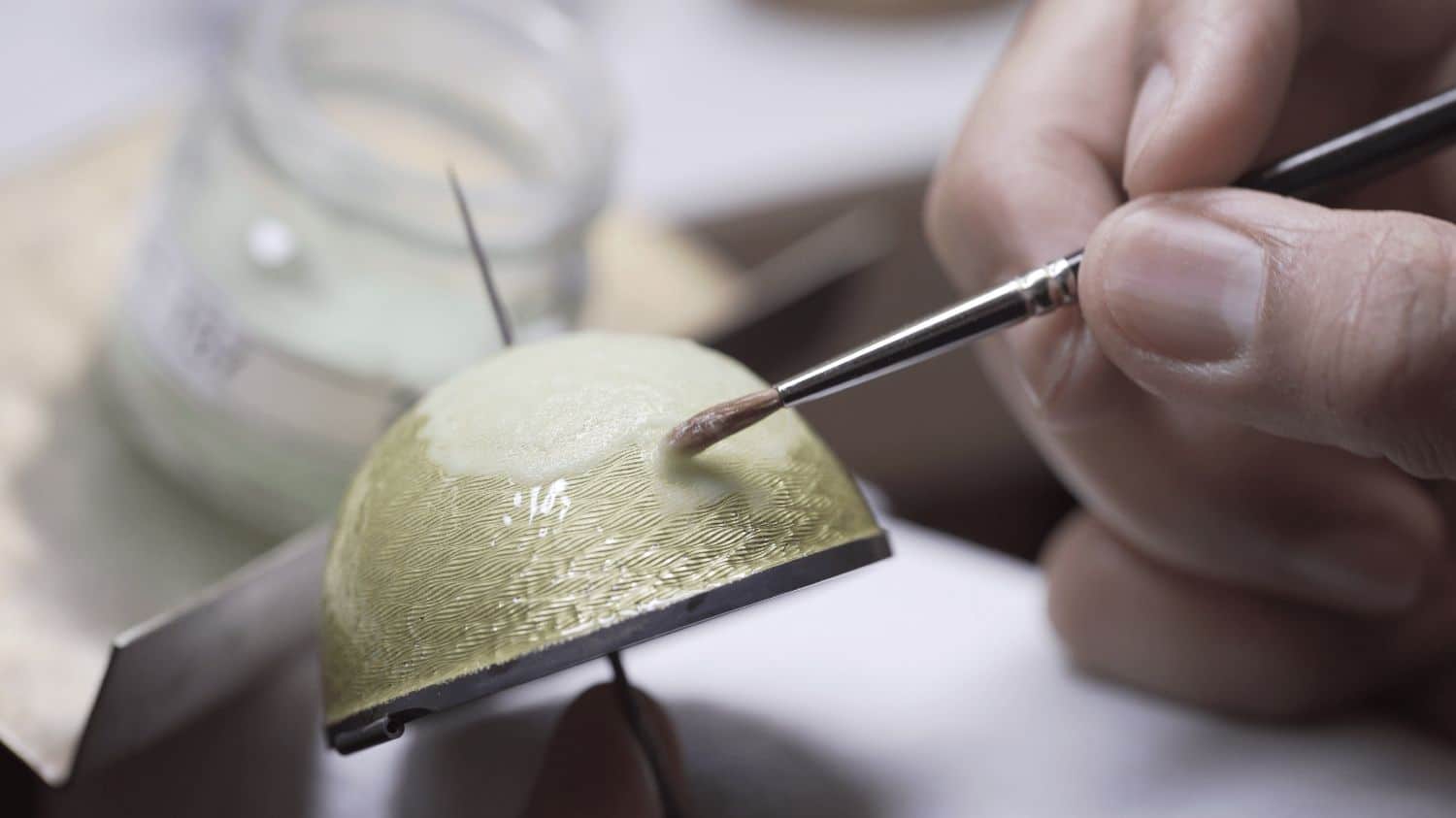 A person painting a celtic egg from a rare whiskey set