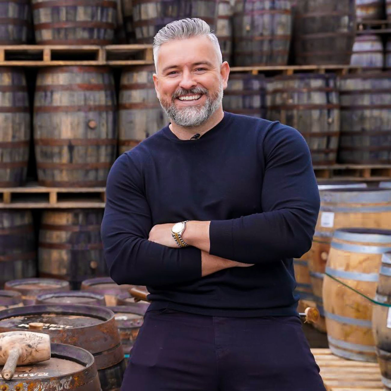 Jay Bradley standing in front of whiskey barrels