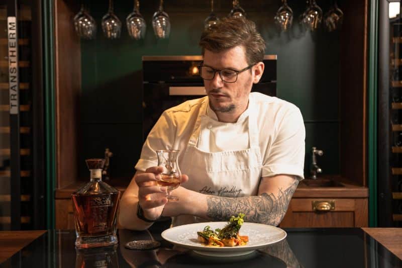 Adam Handling, a plate of food and a glass of craft whiskey