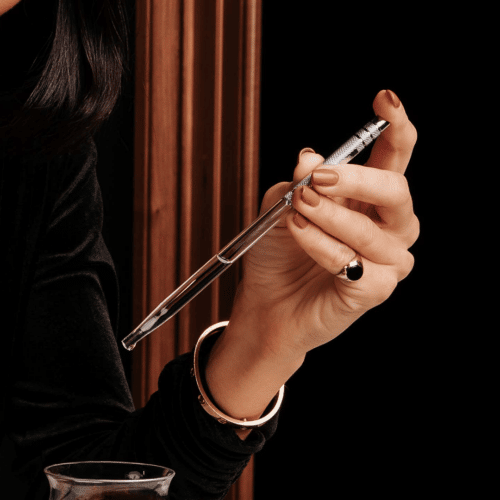 A woman holding a pipette with luxury Irish whiskey