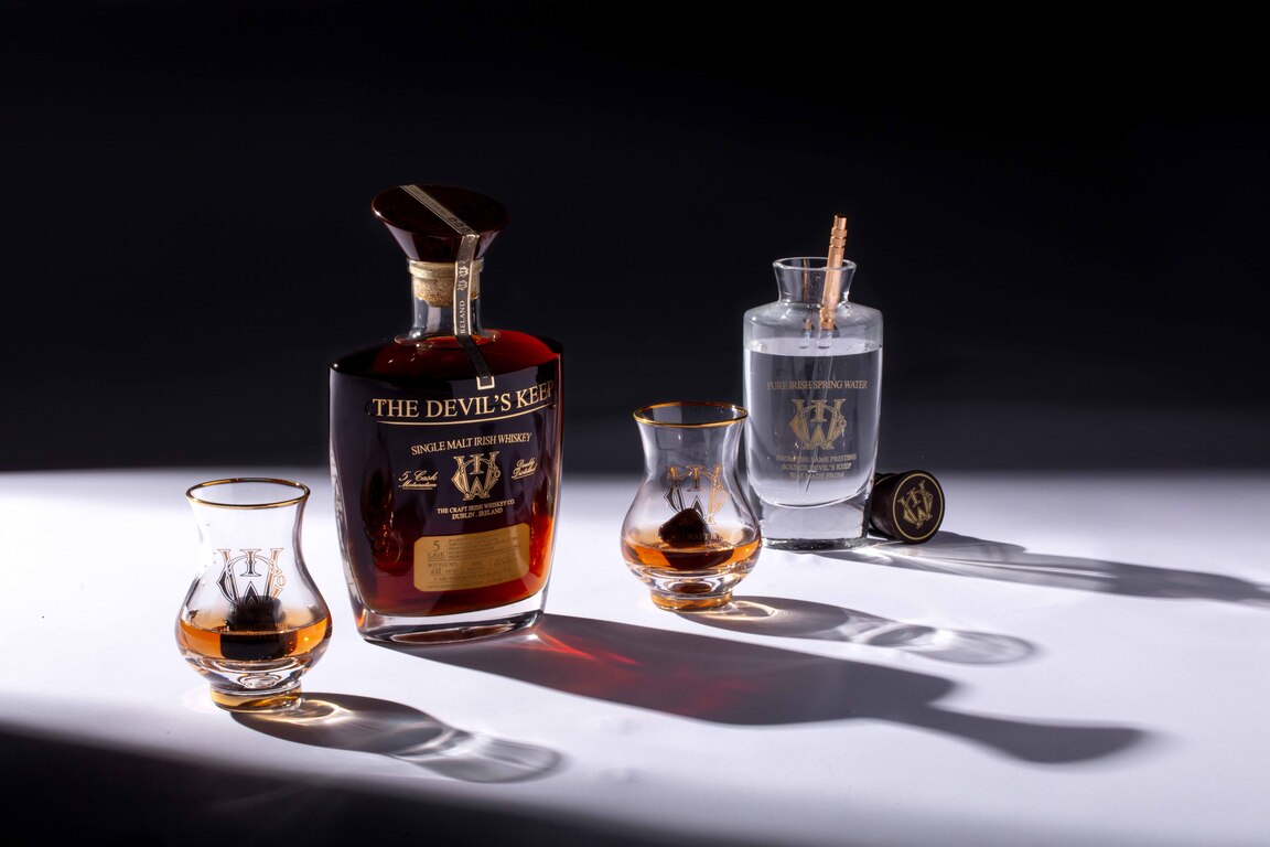 Luxury Irish whiskey bottle The Devil’s Keep 2023 Edition and Érimón whiskey glasses.